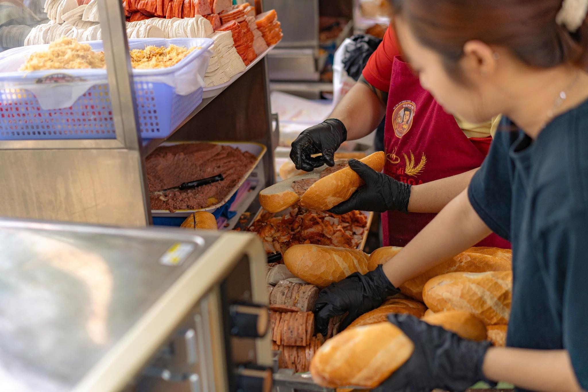 Huỳnh Hoa staff assembling the famous Saigon bánh mì - Source: Banh Mi Huynh Hoa